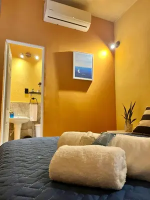a bedroom with a bed and a bathroom with a sink at La Casita in Santa Ana