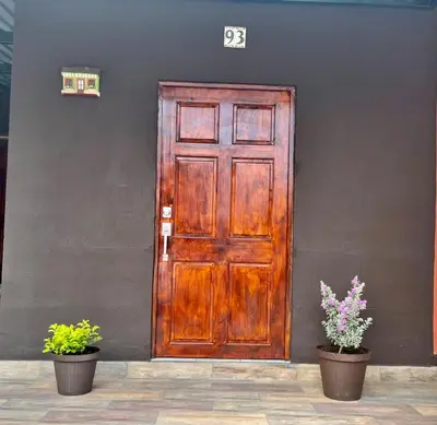 a wooden door with two potted plants in front of a building at La Casita in Santa Ana