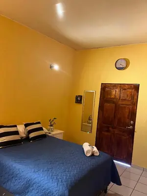 a bedroom with a blue bed and a clock on the wall at La Casita in Santa Ana