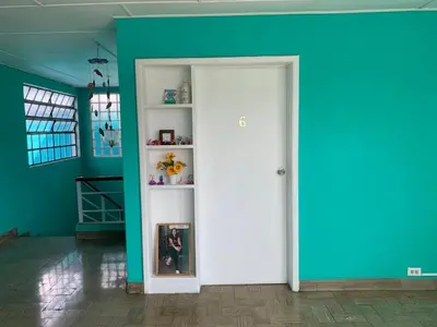 a room with a white door and a blue wall at Hostal primaveras nest centro santa ana hab2 in Santa Ana