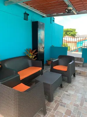 a patio with chairs and tables and a blue wall at Hostal primaveras nest centro santa ana hab2 in Santa Ana