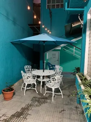 a table and chairs with an umbrella on a patio at Hostal primaveras nest centro santa ana hab2 in Santa Ana