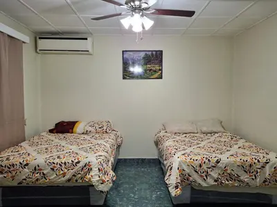 a room with two beds and a ceiling fan at Hostal primaveras nest centro santa ana hab2 in Santa Ana