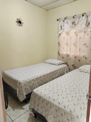 a bedroom with two beds and a spider on the wall at bonita casa pequeña in Santa Ana