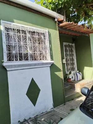a green house with a window and a staircase at bonita casa pequeña in Santa Ana