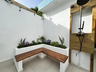 a bench in the corner of a room with plants at Villas de Carolina in San Salvador