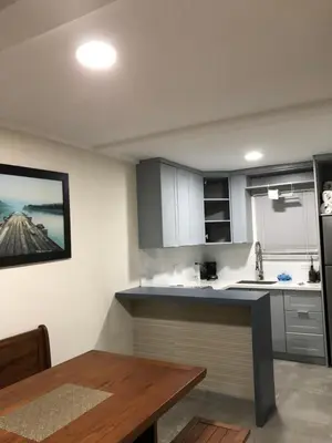 a kitchen with white cabinets and a wooden table at Villas de Carolina in San Salvador