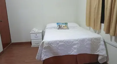 a bedroom with a bed with a dog pillow on it at Ibania Hostal in Tamanique