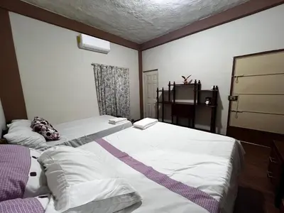 a bedroom with two beds and a table at Ibania Hostal in Tamanique