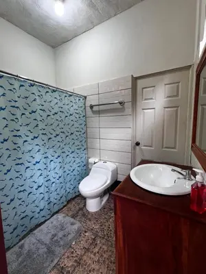 a bathroom with a toilet and a sink at Ibania Hostal in Tamanique