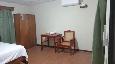 a bedroom with a table and a chair and a desk at Ibania Hostal in Tamanique