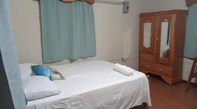 a bedroom with a bed and a dresser and a mirror at Ibania Hostal in Tamanique