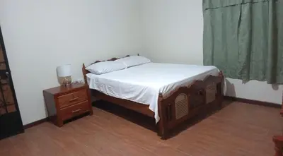 a bedroom with a bed and a dresser and a window at Ibania Hostal in Tamanique