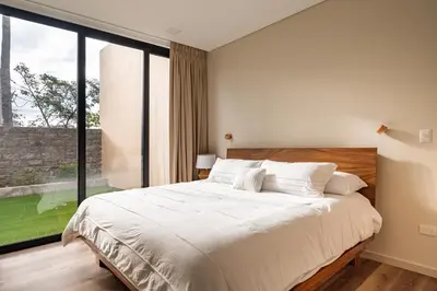 a bedroom with a large bed and a large window at Wave House in El Zonte