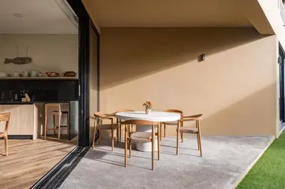 a dining room with a white table and chairs at Wave House in El Zonte