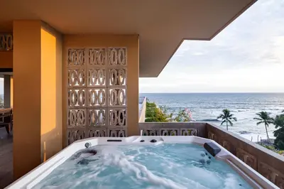 a jacuzzi tub on a balcony with the ocean at Wave House in El Zonte