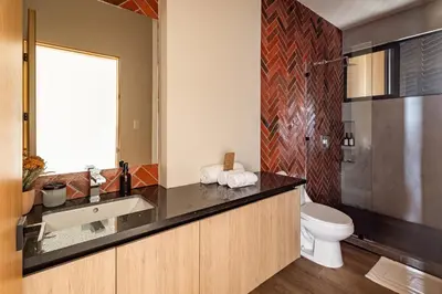 a bathroom with a sink and a toilet at Wave House in El Zonte