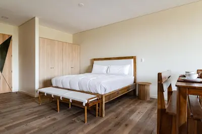 a bedroom with a bed with a bench in it at Wave House in El Zonte