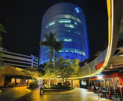 a large blue building with a palm tree in front of it at Apartamento dos habitaciones baños completos WiFi y AC todo el apto, parqueo interno,San Salvador, Colonia escalón in San Salvador