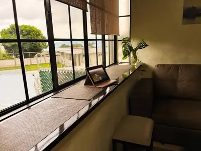 a laptop sitting on a window sill next to a couch at Apartamento dos habitaciones baños completos WiFi y AC todo el apto, parqueo interno,San Salvador, Colonia escalón in San Salvador