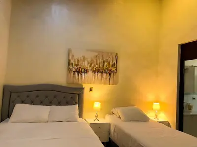 a bedroom with two beds and a painting on the wall at Apartamento dos habitaciones baños completos WiFi y AC todo el apto, parqueo interno,San Salvador, Colonia escalón in San Salvador