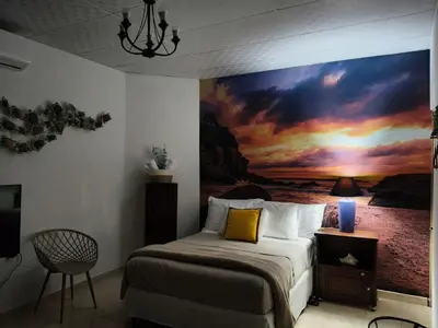a bedroom with a large painting on the wall at Lofts #9 & #6 Surf EcoVilla Playa El Sunzal in El Sunzal