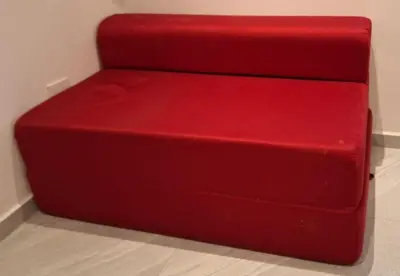 a red couch sitting on top of a floor at Lofts #9 & #6 Surf EcoVilla Playa El Sunzal in El Sunzal