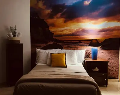 a bedroom with a bed with a painting on the wall at Lofts #9 & #6 Surf EcoVilla Playa El Sunzal in El Sunzal