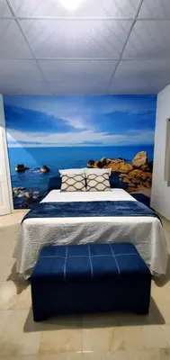 a bedroom with a bed with a painting of the ocean at Lofts #9 & #6 Surf EcoVilla Playa El Sunzal in El Sunzal