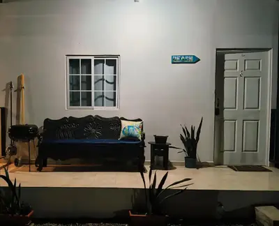 a living room with a black couch and a window at Lofts #9 & #6 Surf EcoVilla Playa El Sunzal in El Sunzal