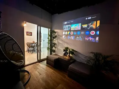 a living room with a large screen on the wall at Casa Los Ausoles con Jacuzzi in Ahuachapán