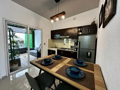 a kitchen with a wooden table with plates on it at Casa Los Ausoles con Jacuzzi in Ahuachapán
