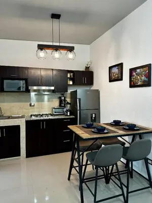 a kitchen with a table and two chairs in it at Casa Los Ausoles con Jacuzzi in Ahuachapán