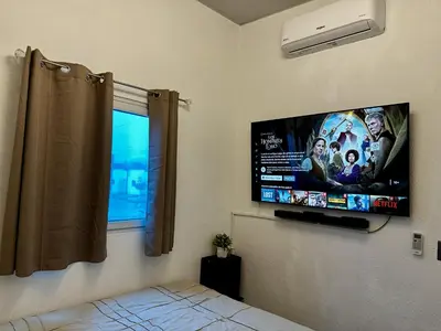 a bedroom with a flat screen tv on the wall at Casa Los Ausoles con Jacuzzi in Ahuachapán