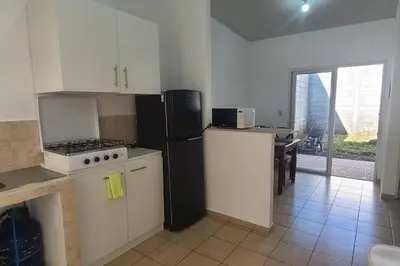 a kitchen with a black refrigerator and a stove at Residencia en Megápolis, San Miguel in San Miguel