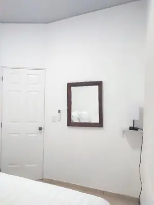a white bedroom with a mirror and a bed at KIRAz in Turín