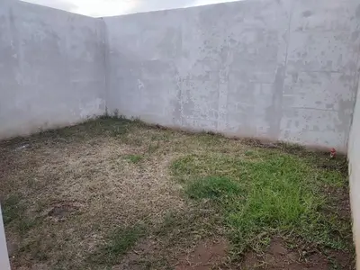 an empty room with a concrete wall and grass at KIRAz in Turín