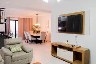 a living room with a television and a table with chairs at Beautiful Modern Home in Res San Andres in San Miguel