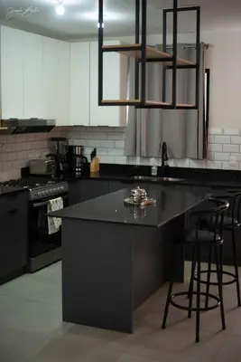 a kitchen with a black counter and stools in it at Beautiful Modern Home in Res San Andres in San Miguel
