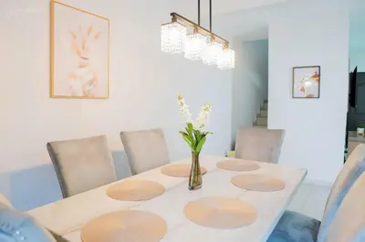 a dining room table with chairs and a vase with flowers at Beautiful Modern Home in Res San Andres in San Miguel
