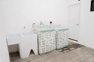 a white bathroom with a sink and a table at Beautiful Modern Home in Res San Andres in San Miguel