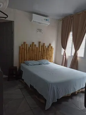 a bedroom with a large bed with a wooden headboard at Las Brisas Casa frente al mar Costa del Sol in El Zapote