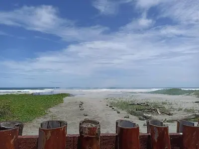 a view of a beach from a wooden fence at Las Brisas Casa frente al mar Costa del Sol in El Zapote