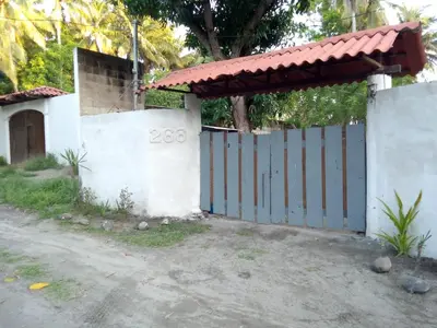 a house with a blue gate and a fence at Las Brisas Casa frente al mar Costa del Sol in El Zapote