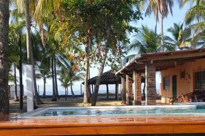 a house with a swimming pool and palm trees at Sihua Escape in Teotepeque
