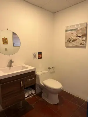 a bathroom with a toilet and a sink and a mirror at Sihua Escape in Teotepeque