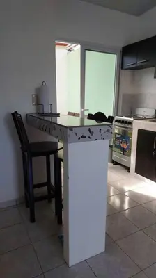 a kitchen with a counter and a table with a chair at Confort Express en San Miguel in San Miguel