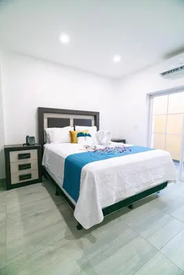 a bedroom with a large bed with a blue blanket at Chalatenango Country Club & Resort in Chalatenango