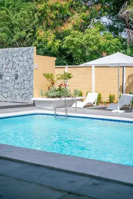 a swimming pool with two chairs and an umbrella at Chalatenango Country Club & Resort in Chalatenango