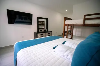 a bedroom with a bed and a tv and a bunk bed at Chalatenango Country Club & Resort in Chalatenango